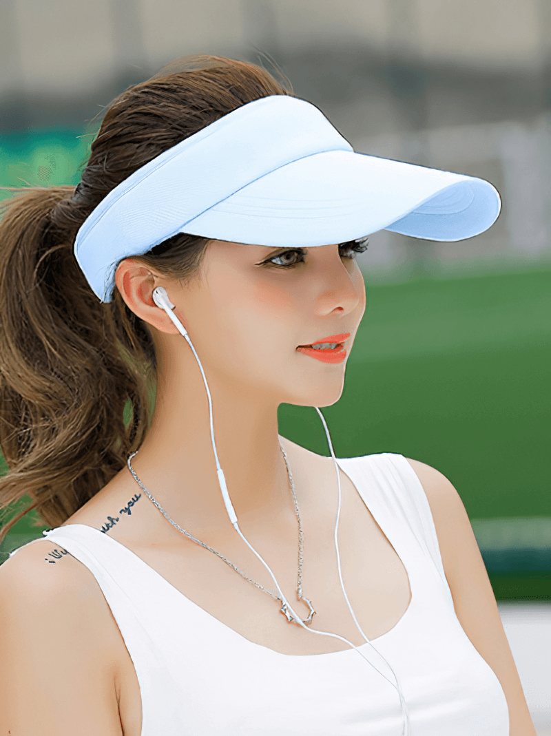 Woman wearing light blue tennis golf visor cap with UV protection, adjustable fit, and solid design outdoors.